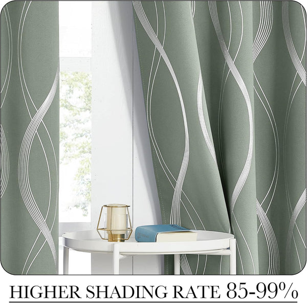 Thick sage green blackout curtains featuring a vertical silver wavy pattern, elegantly draped by a window.