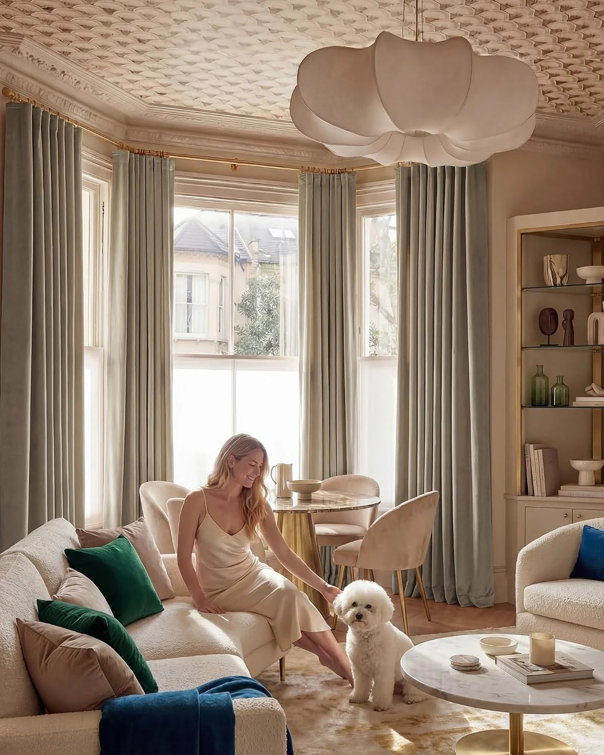 Soft sage pleated curtains in an elegant living room with boucle seating and marble table