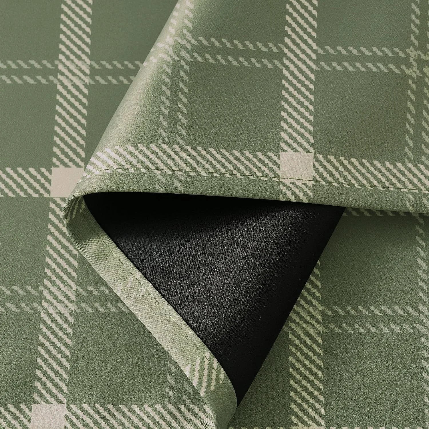 Close-up of sage green plaid blackout curtain fabric with black lining