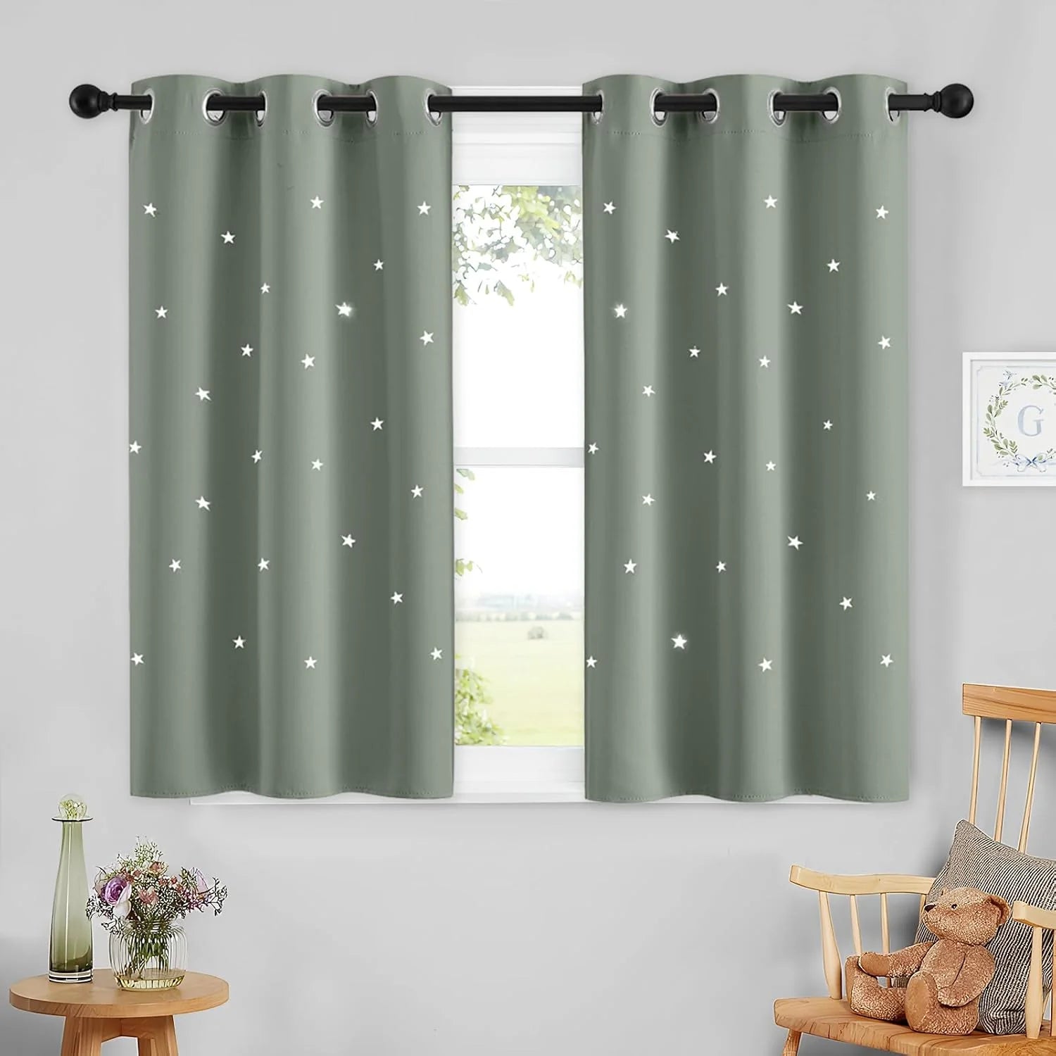Sage green kids curtains with white star cutouts and silver grommets on a window