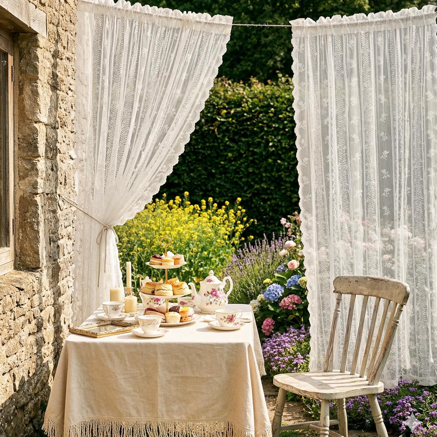 Sheer white lace curtains with delicate floral patterns and scalloped edges draped in a charming garden setting.