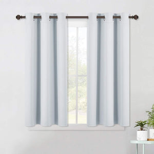 Two light blue short curtains with silver grommet tops on a dark rod, covering a bright window.