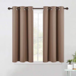 Pair of short mocha brown room darkening curtains with silver grommets hanging on a dark rod above a window.