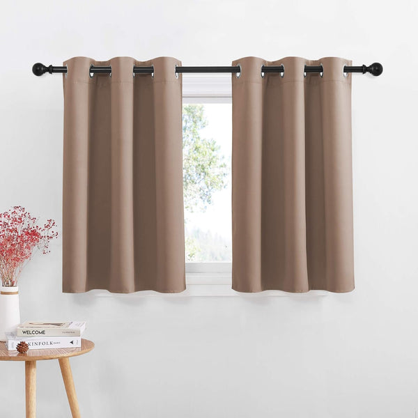 Pair of solid taupe short window curtains with silver grommet tops on a black rod.