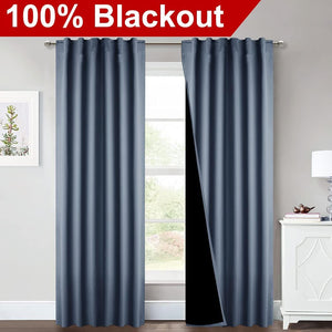 Slate blue blackout curtains with rod pocket top, one panel revealing black thermal lining.