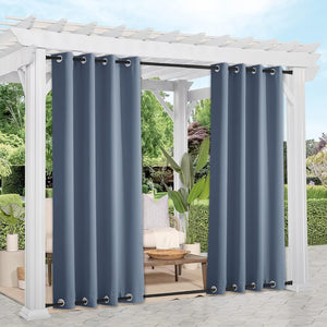 Slate blue outdoor patio curtains with top and bottom grommets, hanging on a white pergola.