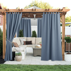 Slate blue tab top outdoor curtains on a wooden pergola, providing privacy for a patio lounge.
