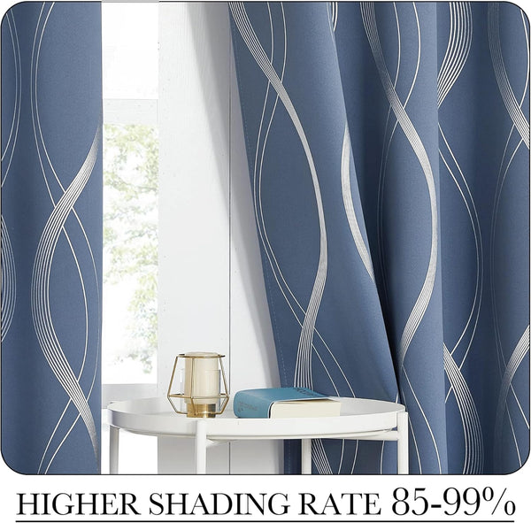Elegant slate blue blackout curtains with silver wavy patterns hanging by a window.