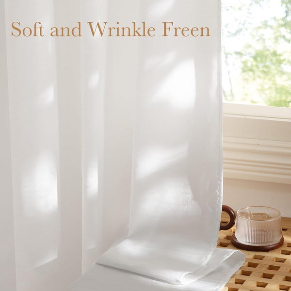 Close up of a soft white sheer window curtain, showing its wrinkle-free fabric and light filtering effect.