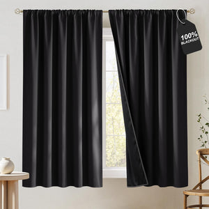 Solid black 100% blackout curtains with a gathered top on a gold rod, one panel slightly open.