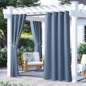 Two panels of steel blue outdoor grommet curtains provide privacy on a patio pergola.