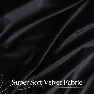 Close-up of draped super soft black velvet fabric showing luxurious folds and subtle sheen.