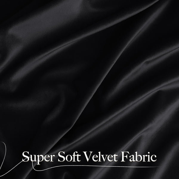 Close-up of draped super soft black velvet fabric showing luxurious folds and subtle sheen.