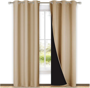 Tan blackout window curtains with silver grommet tops hanging, revealing dark lining.