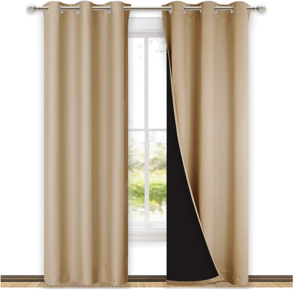 Tan blackout window curtains with silver grommet tops hanging, revealing dark lining.