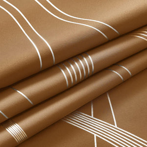 Folded tan fabric featuring a modern geometric pattern of shiny silver lines. Smooth textured curtain material.