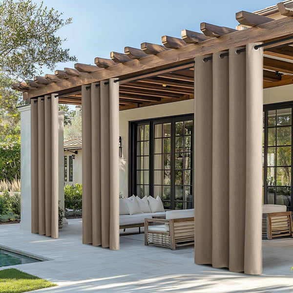 Tan outdoor grommet curtains hanging from a wooden pergola, providing privacy and shade for a patio area.