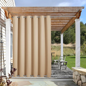 Tan outdoor grommet curtain hanging on a wooden pergola, providing privacy and shade for a patio.