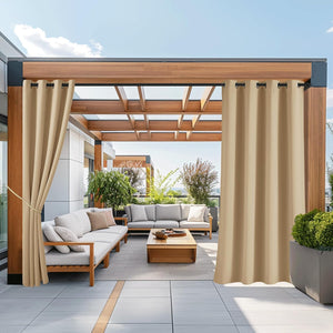 Tan outdoor patio curtains with grommet tops draped over a modern wooden pergola, providing shade.