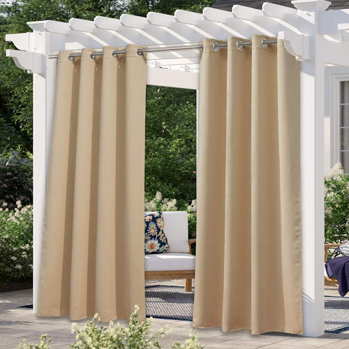 Pair of tan outdoor patio curtains with silver grommet tops hanging on a white pergola.