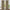 Tan textured window curtains with subtle dark plaid pattern, hung with back tabs on a wooden rod.