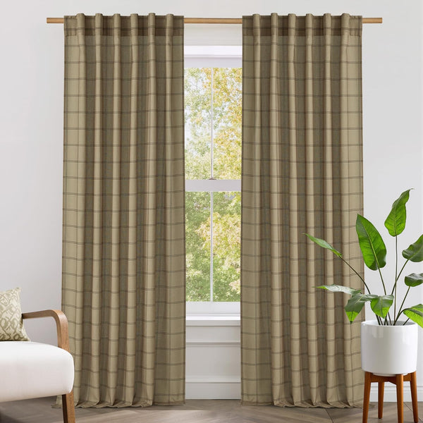 Tan textured window curtains with subtle dark plaid pattern, hung with back tabs on a wooden rod.