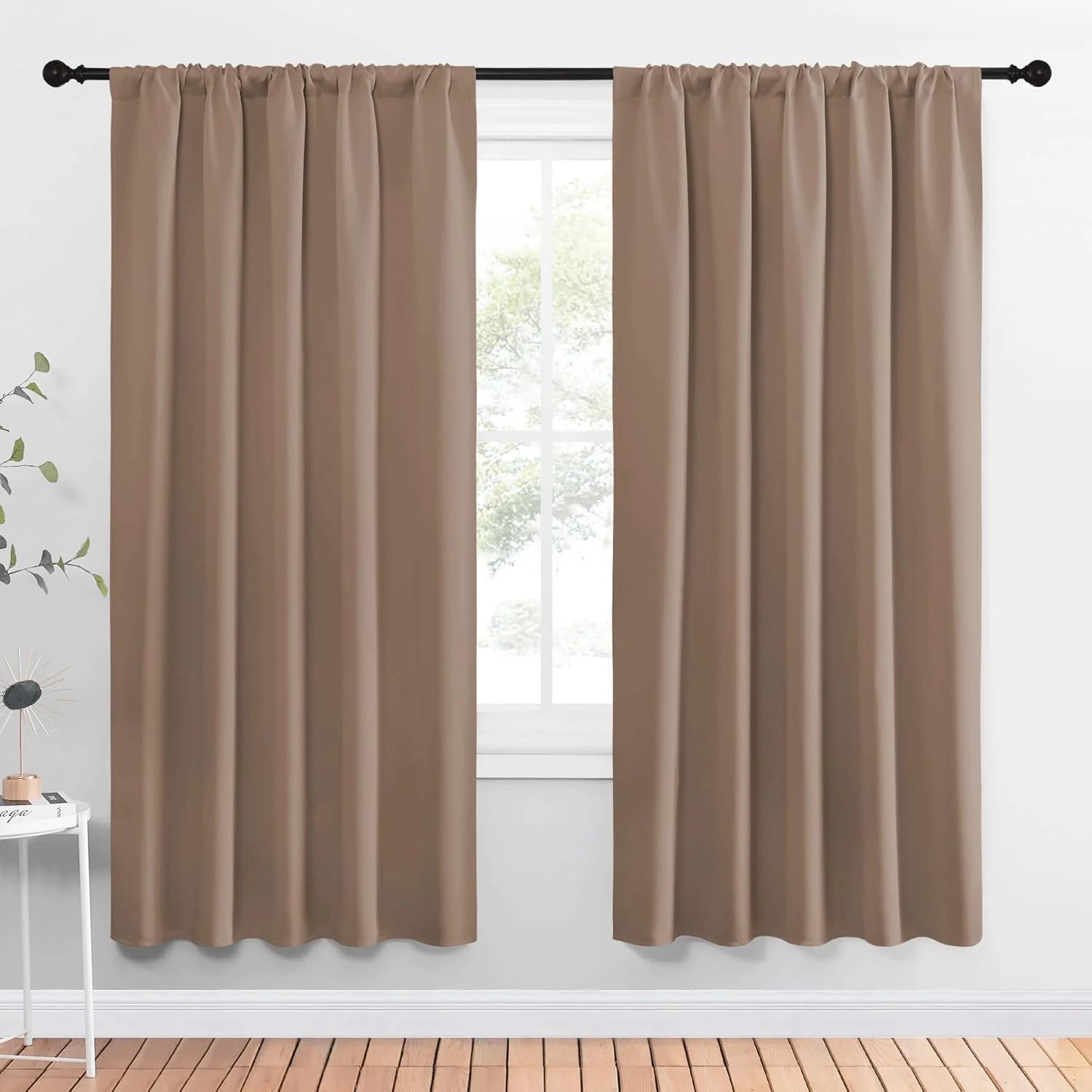 Taupe blackout curtain panels with rod pocket top hanging on a black curtain rod