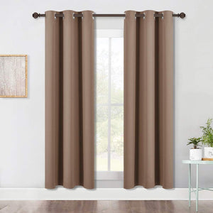 Taupe brown blackout grommet top curtains hanging on a dark rod over a window.