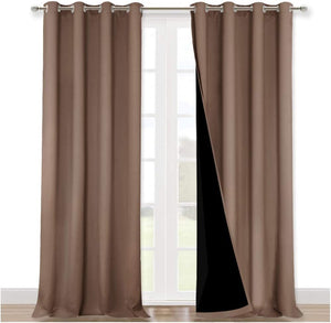 Pair of taupe blackout curtains with silver grommet tops on a window rod, revealing black lining.
