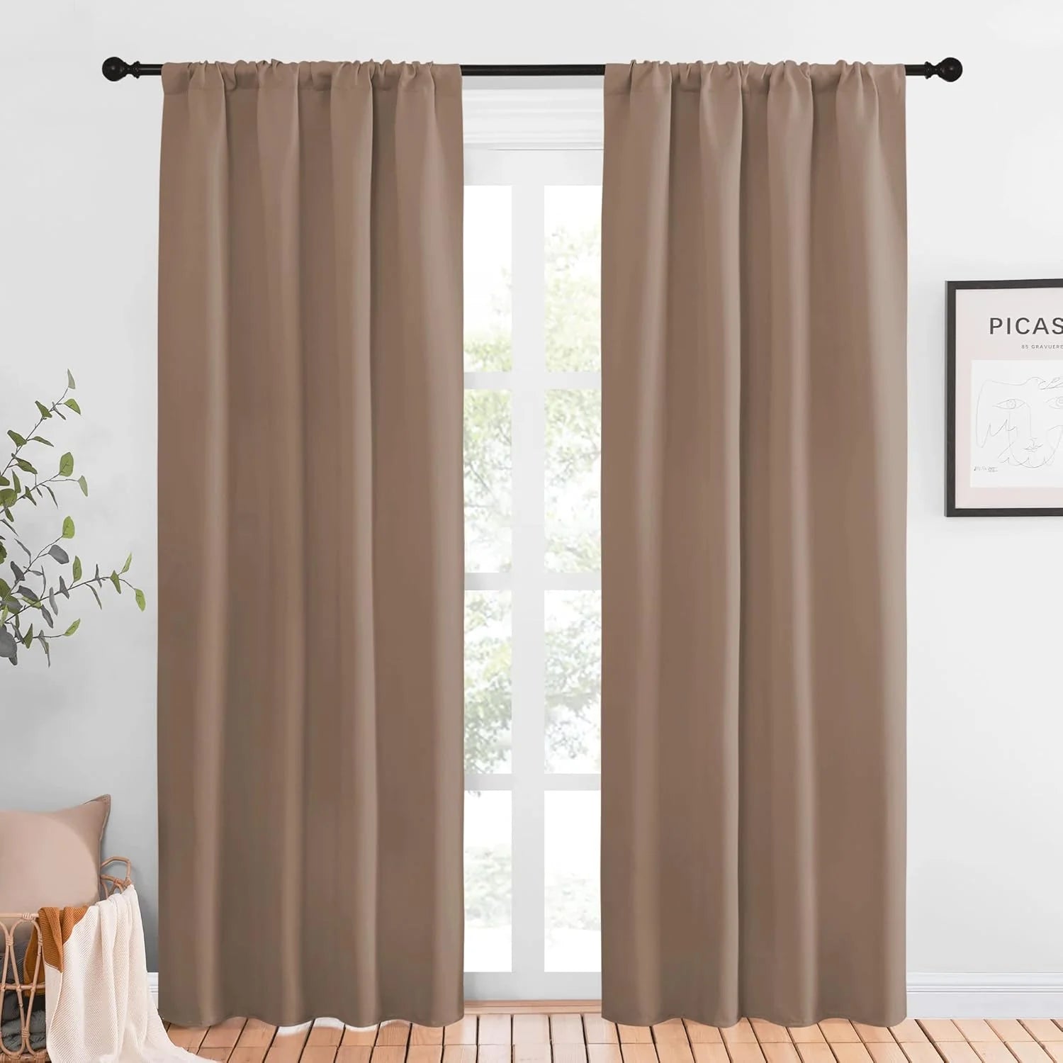 Taupe blackout curtains with rod pocket top hanging on a black curtain rod