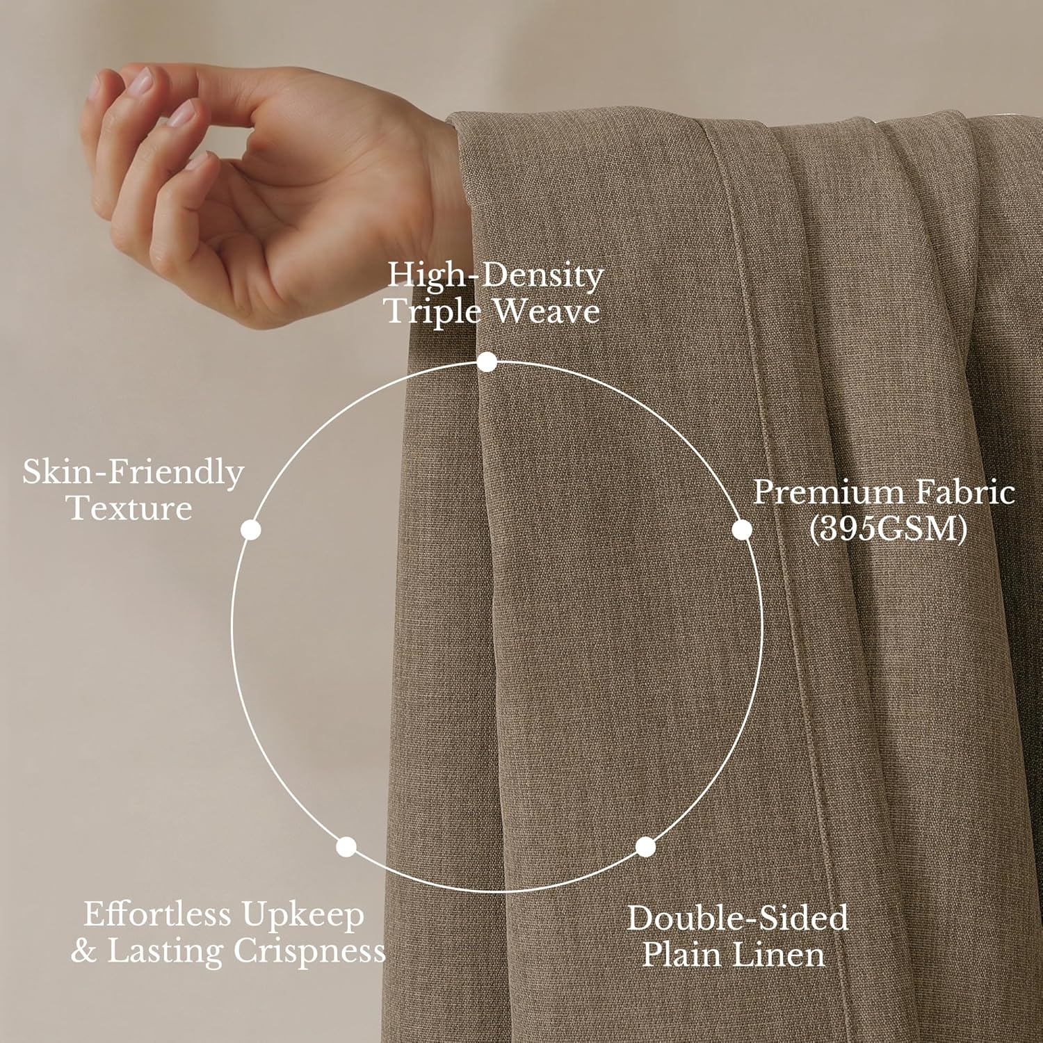 Close-up of a hand gently holding a high-density taupe linen fabric, showcasing its tight weave and soft drape.