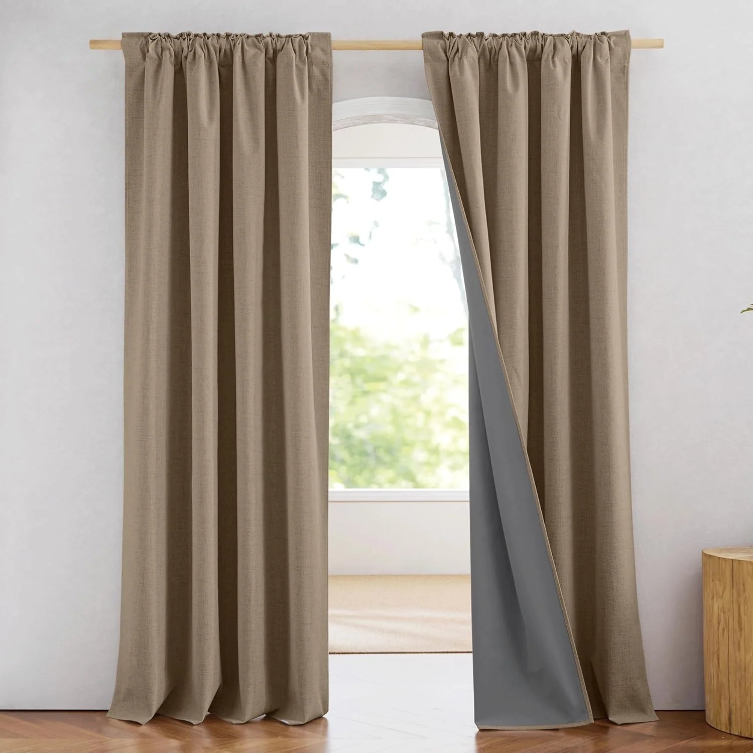 Taupe linen-look blackout curtains with rod pocket top hanging on a wooden curtain rod