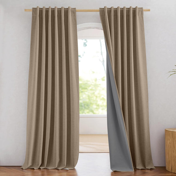 Textured taupe back tab blackout curtains revealing dark grey lining over a window.