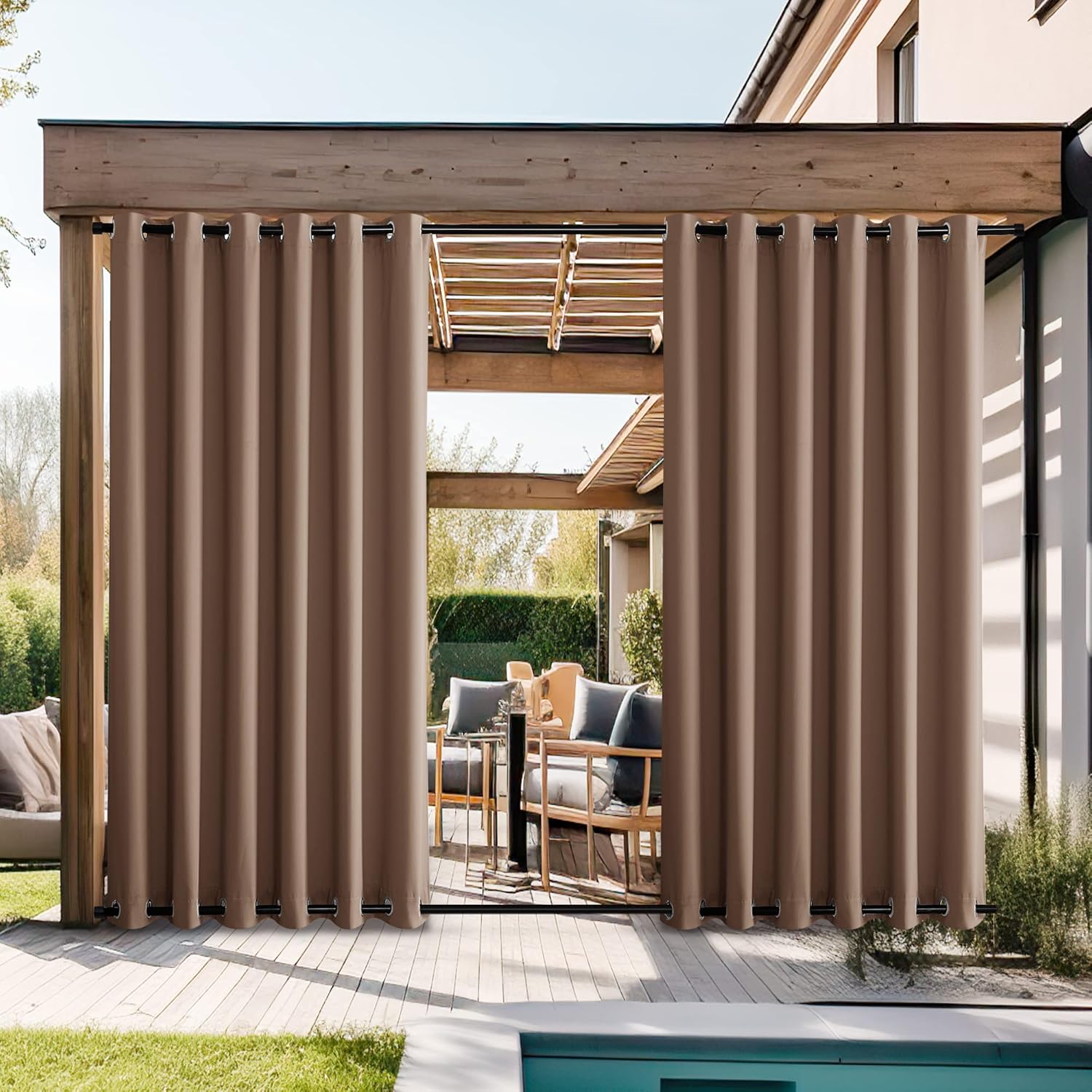 Taupe outdoor privacy curtains with grommets hanging from a wooden pergola over a patio.
