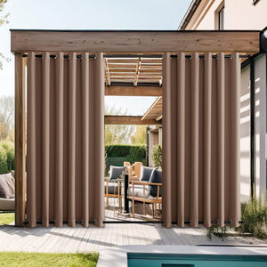 Taupe outdoor privacy curtains with grommets hanging from a wooden pergola over a patio.