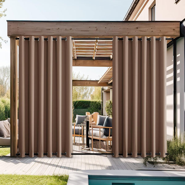 Taupe outdoor privacy curtains with grommets hanging from a wooden pergola over a patio.