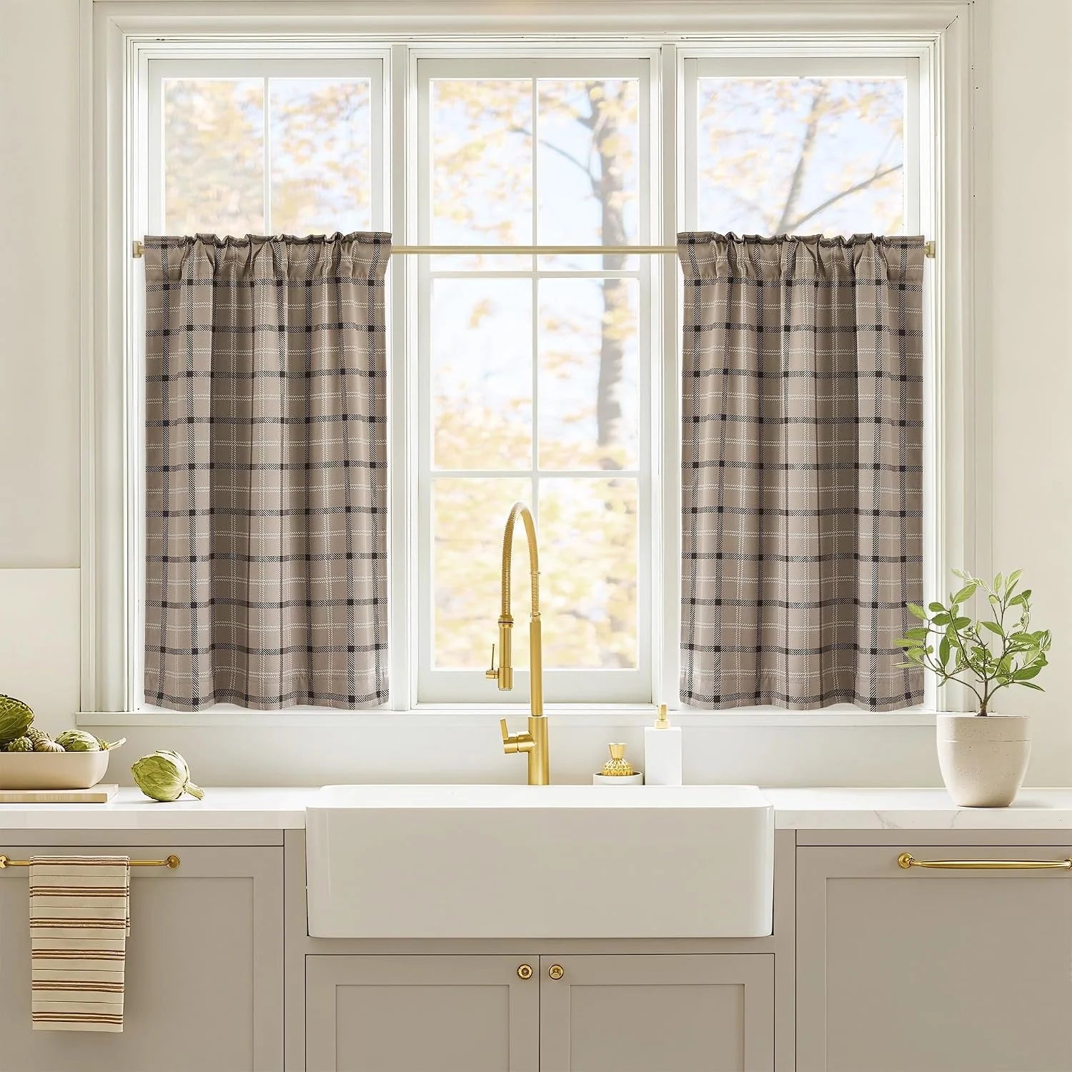 Taupe plaid cafe curtains on a kitchen window above a white farmhouse sink