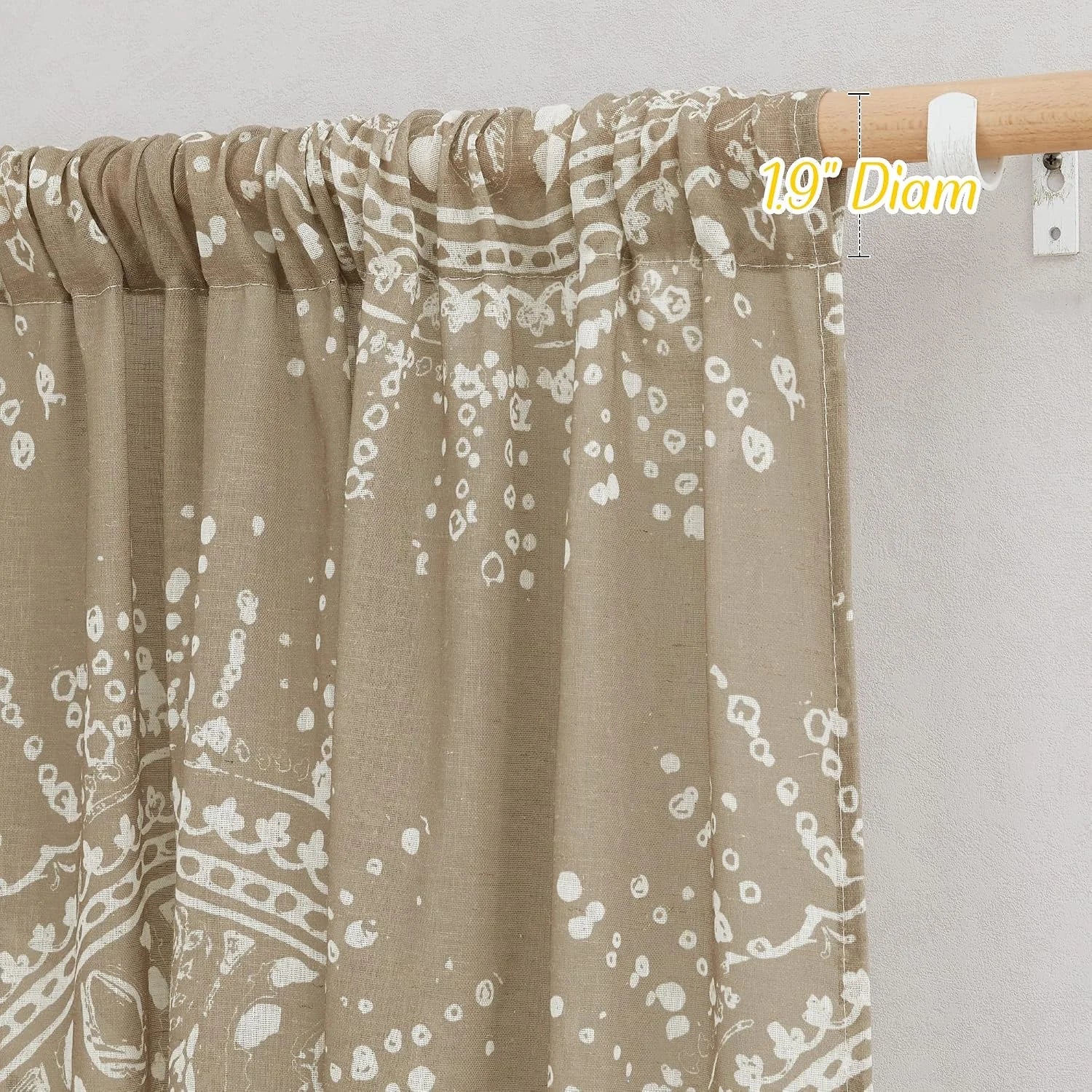 Taupe printed linen curtain with rod pocket header hanging on a wooden curtain rod
