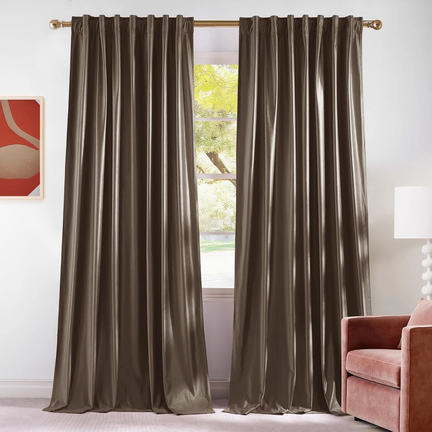 Taupe satin rod pocket curtains hanging on a brass rod in a bright modern room