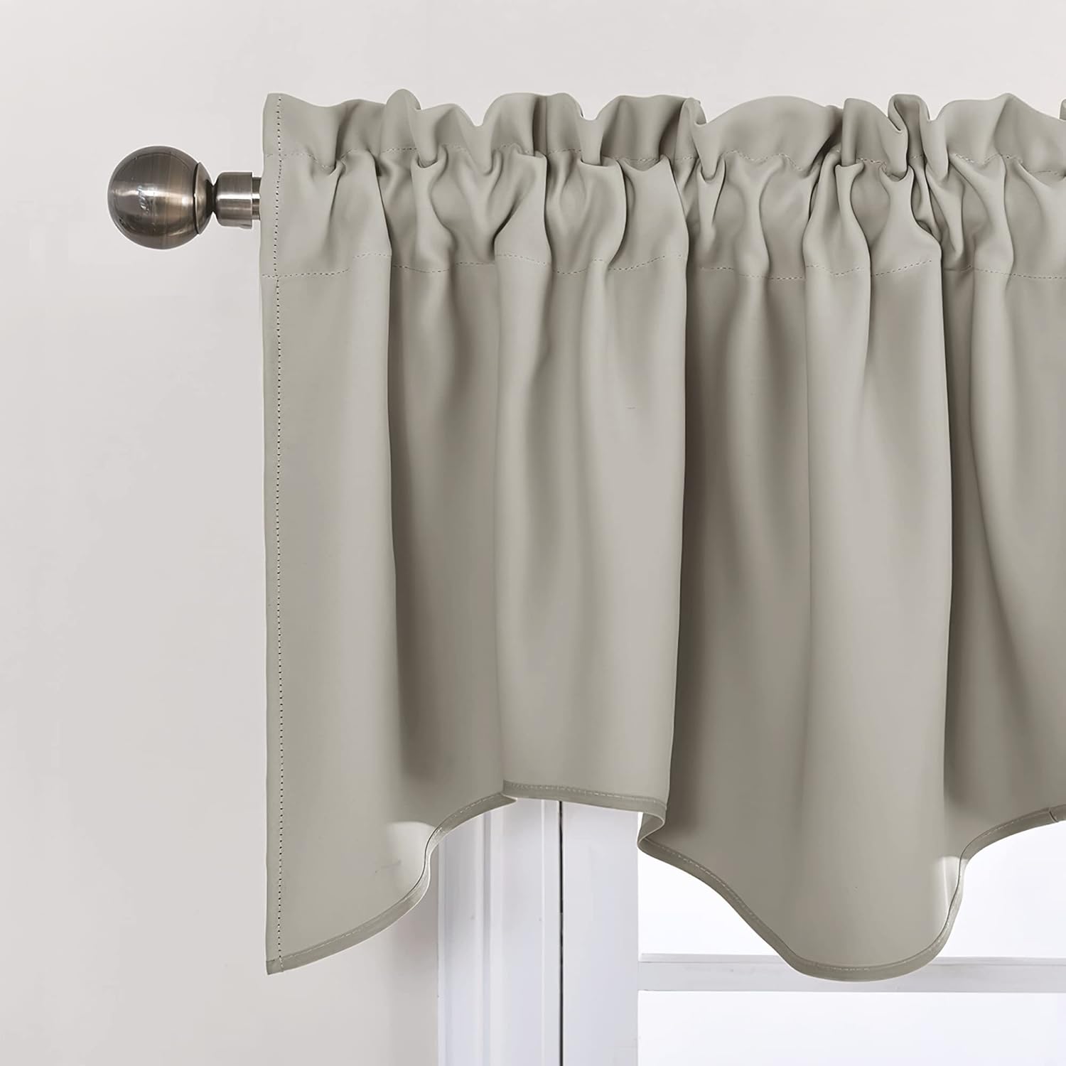 Taupe rod pocket valance with ruffled top and scalloped bottom edge, hung on a bronze curtain rod.