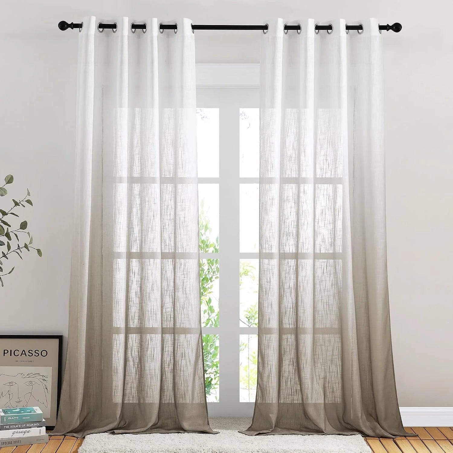 Taupe sheer linen-look curtains with grommet top hanging on a black curtain rod