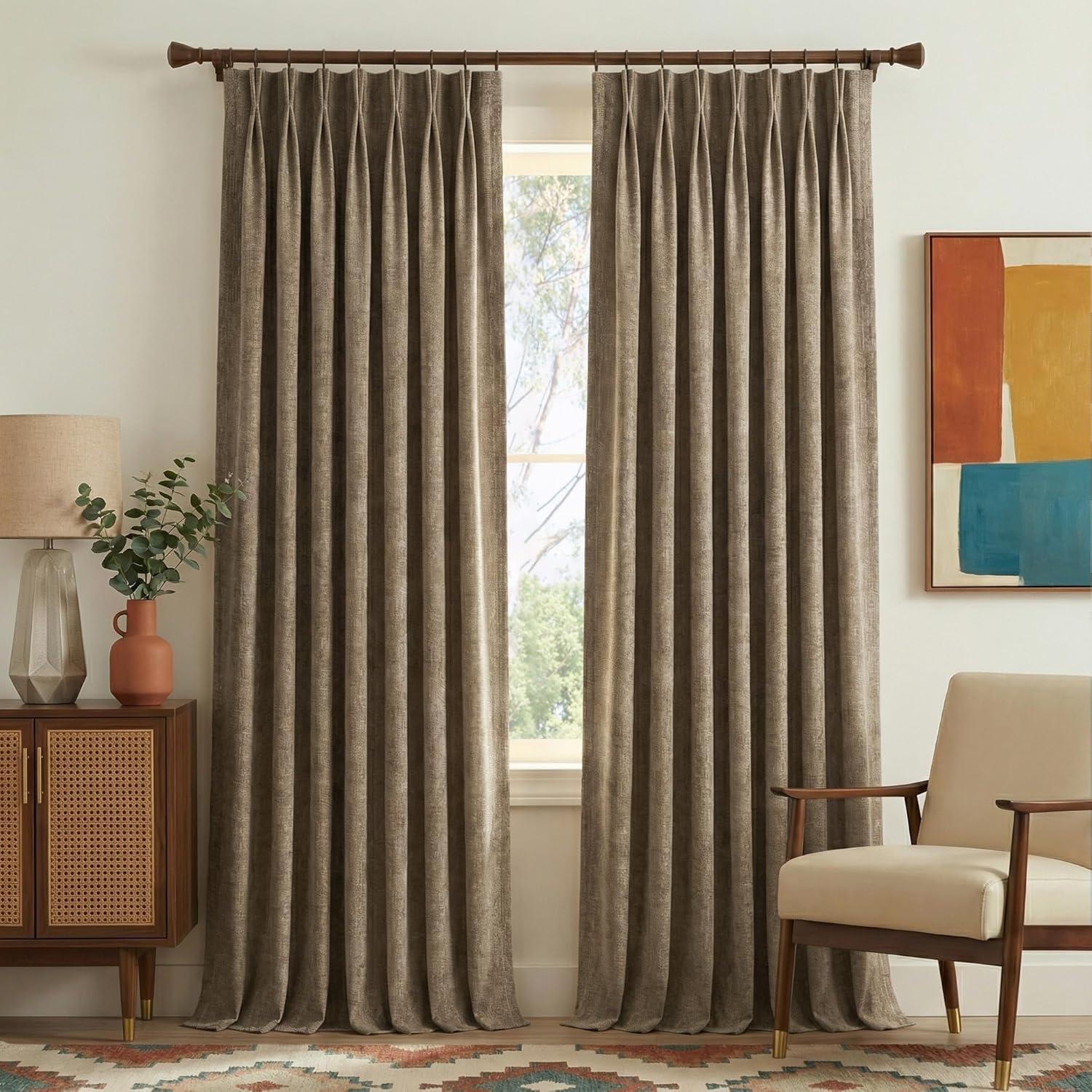 Textured taupe pinch pleat curtains on a dark wood rod, framing a bright window.