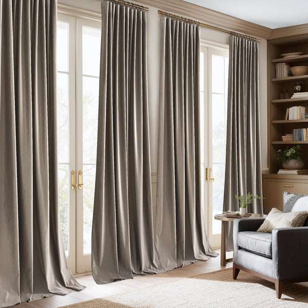 Taupe velvet ring top curtains elegantly hang over french doors, pooling gracefully on the floor.