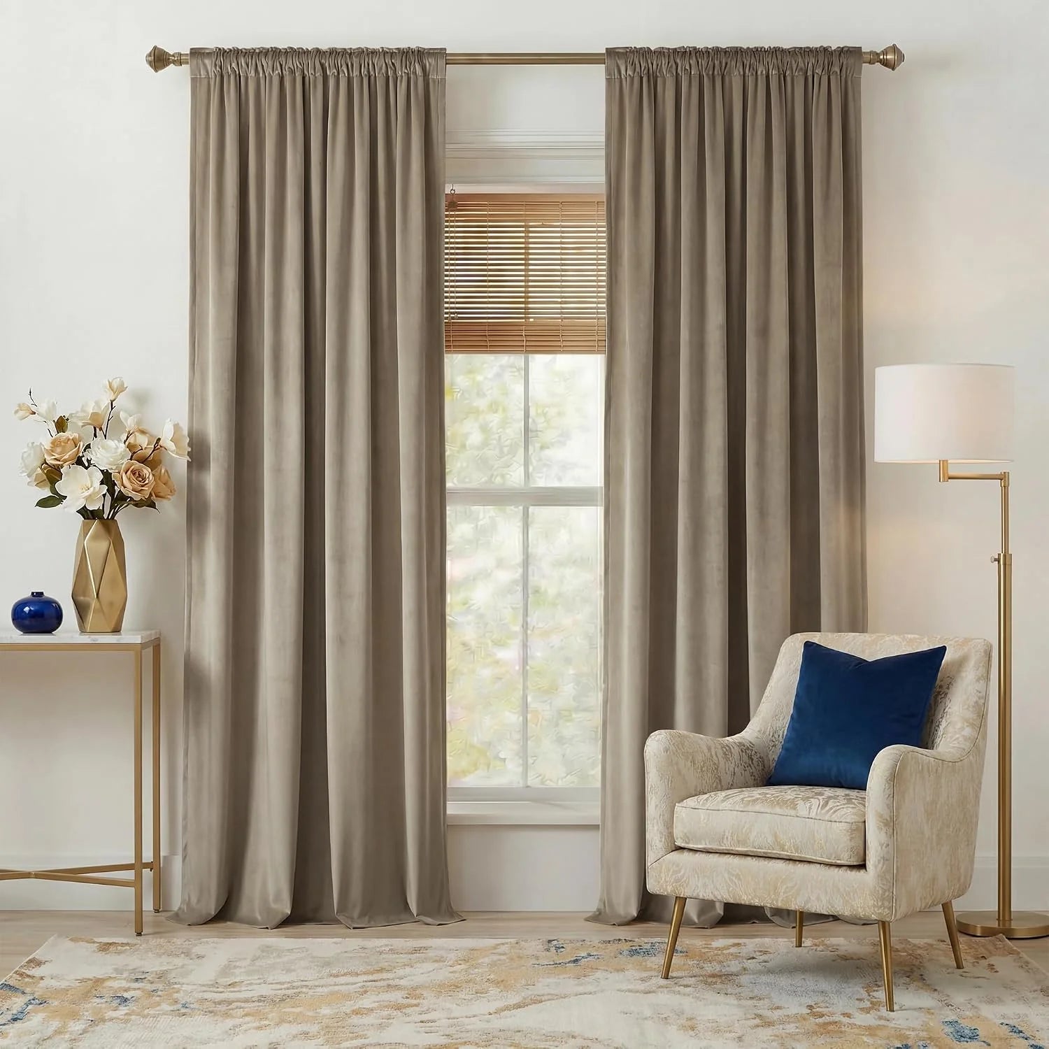 Taupe velvet rod pocket curtains framing a window with blinds in a neutral living room