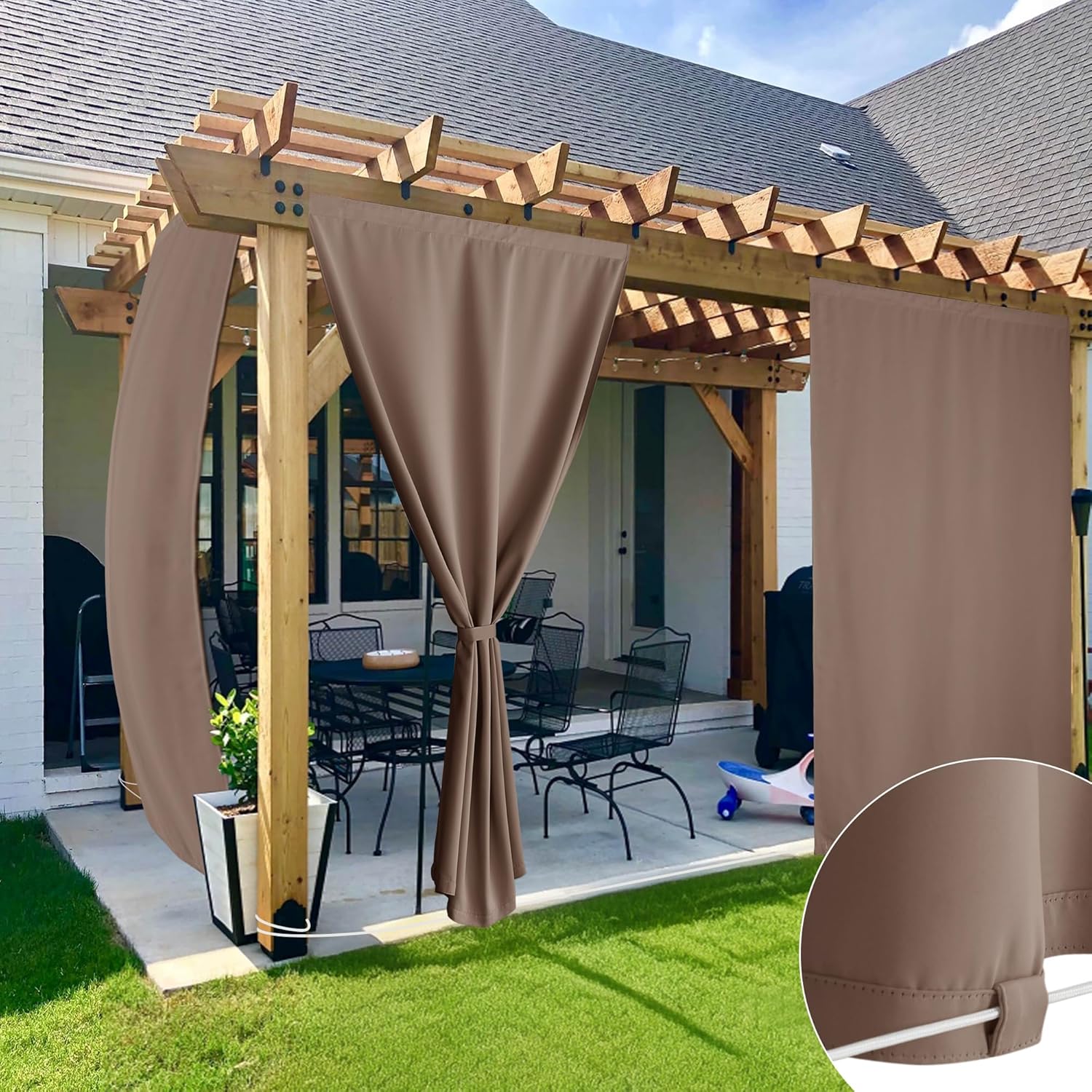 Weatherproof taupe outdoor privacy curtains on a wooden pergola, one panel tied back, showing bottom loops for securing.