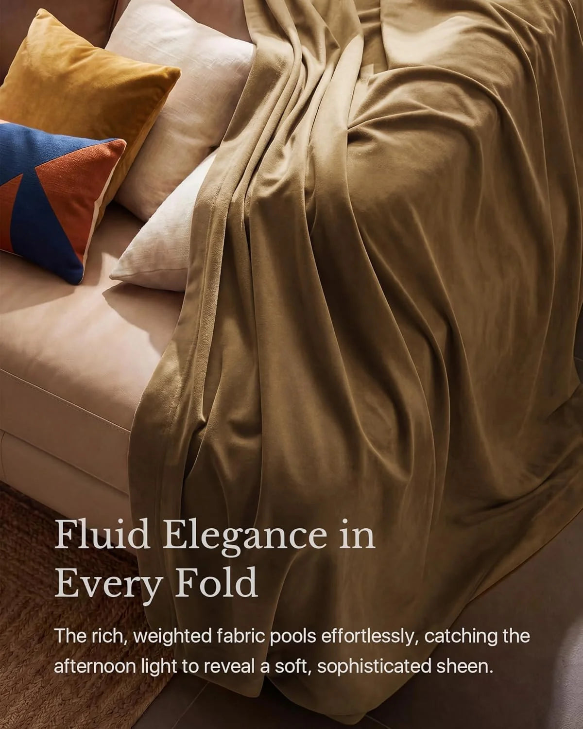 Taupe weighted throw blanket draped over a beige sofa with colorful accent pillows