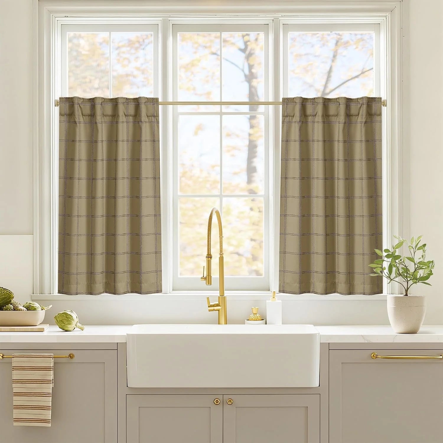 Taupe windowpane cafe curtains on a white kitchen window above a farmhouse sink