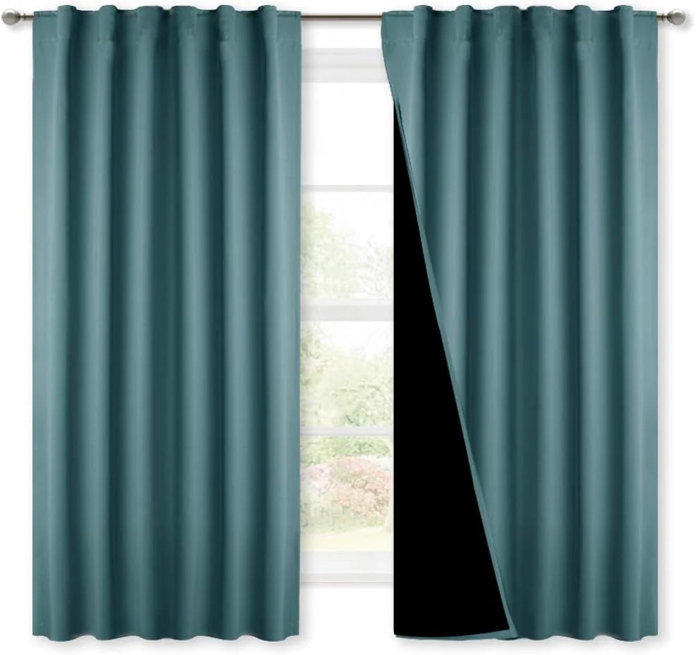 Teal blackout curtains with rod pocket top, one panel pulled back to show black lining