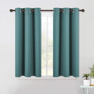 Teal blackout curtains with silver grommet tops hang on a dark brown rod over a white window frame.