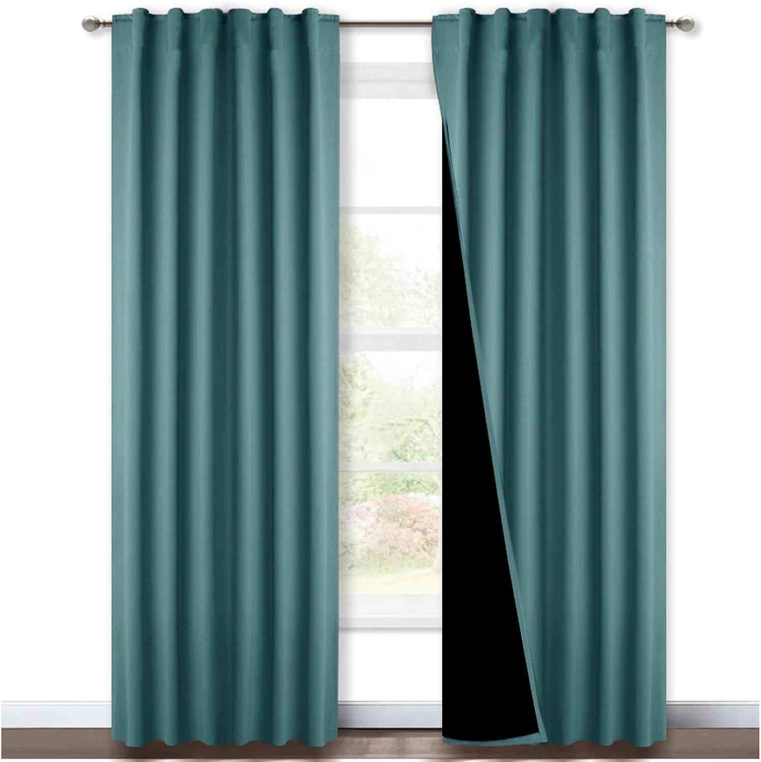 Teal blackout curtains with rod pocket top hanging on a silver curtain rod